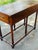 A handsome antique English walnut writing table featuring a rich, warm patina and elegant understated craftsmanship. This...