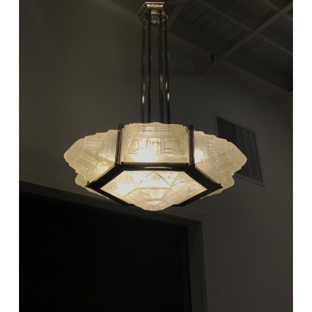 French Art Deco chandelier by the French artist Verrerie des Hanots. Six sided with six geometric shades surround the...