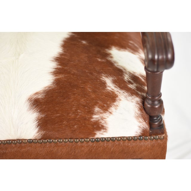 Bold and beautifully reimagined pair of very large antique armchairs, reupholstered in genuine Hereford cowhide. Antique...