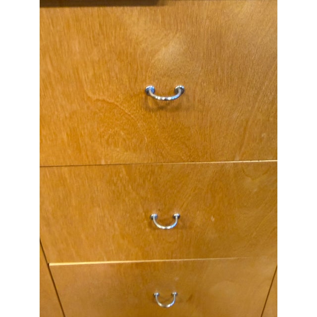 Design Plus Gallery presents a Wardrobing Chest of Seven Drawers. This modern cabinet showcases a light wood veneer with a...