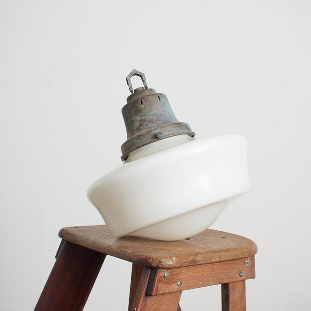 An original opaline glass pendant light. The light has a milk glass opaline shade and original brass hanging gallery. The...