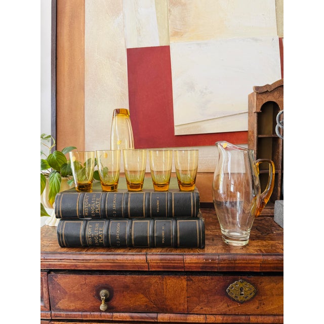 A warm, glow-from-within set that instantly elevates a bar cart or summer table. This hand blown amber glass pitcher...