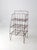 A vintage wire shelf rack with a collapsible frame and three open shelves, dating from the 1940s to 1950s. Its light, open...