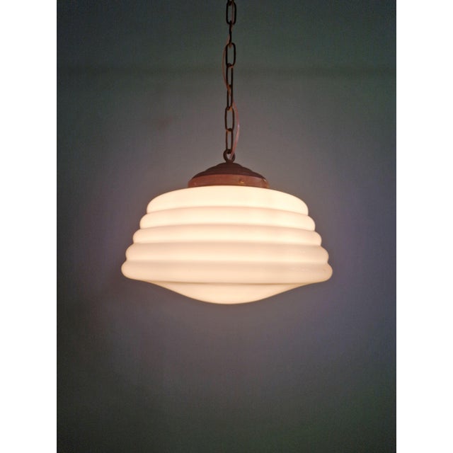 Art Deco pendant light in white opaline glass with a copper-colored metal frame, 1920s-30s. The pendant light has been...