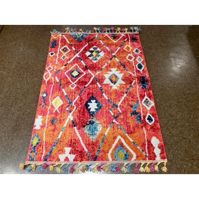 Machine-made Turkish rug in polypropylene featuring a Moroccan-inspired design with a loose diamond lattice and abstract...