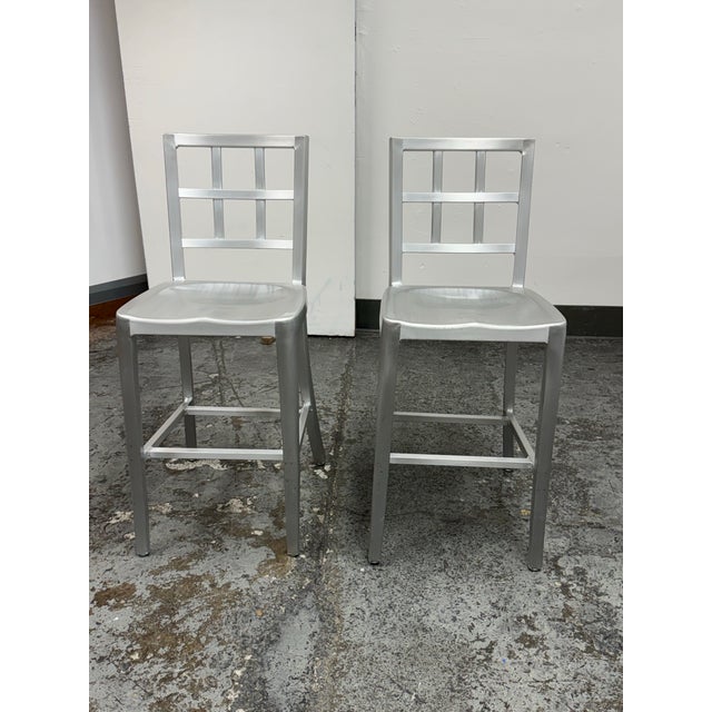 Design Plus Gallery presents a Pair of Industrial Modern Aluminum Ladder Back Counter Stools in the Style of Emeco. Each...