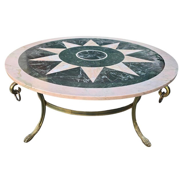 Elegant mid-century round coffee table made in Italy in the 1950s, featuring a richly detailed marble top with inlaid...