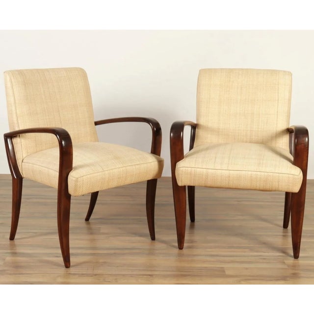 Pair of sleek and sinuous Art Deco revival dark stained maple arm chairs. Covered in woven raffia upholstery and with...