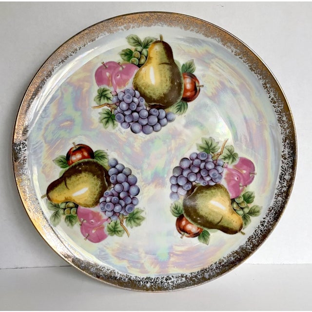 Here is a glamorous set of 8 plates with a matching platter. The plates feature the same fruit motif with a shiny, gold...