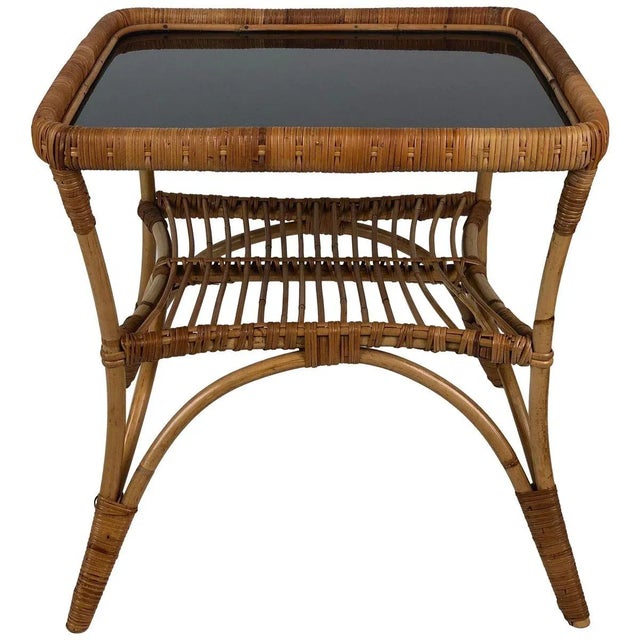 Two chairs with a charming coffee table made in bamboo and wicker. The table has a black Opaline glass top. Italian...