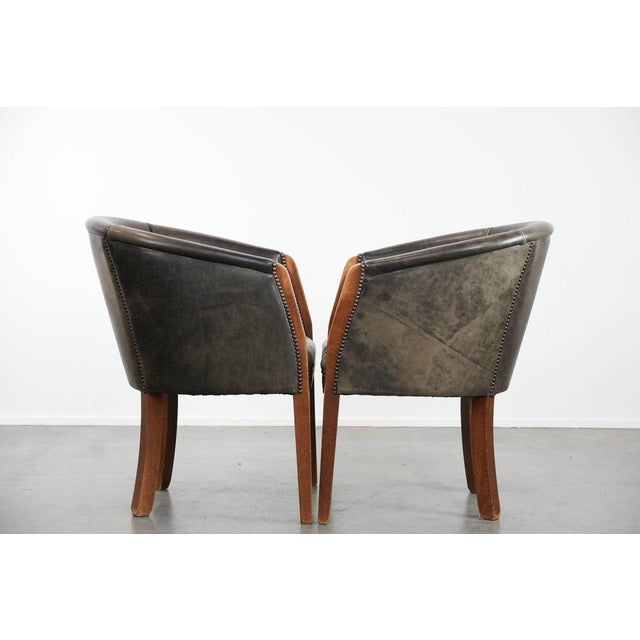 This characterful set of two cowhide tub chairs/side chairs is finished with decorative nails and can easily be placed in...