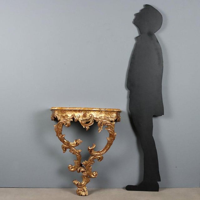 Rococo style drop console, crafted from finely carved and gilded wood, dating back to the early 20th century in Italy....