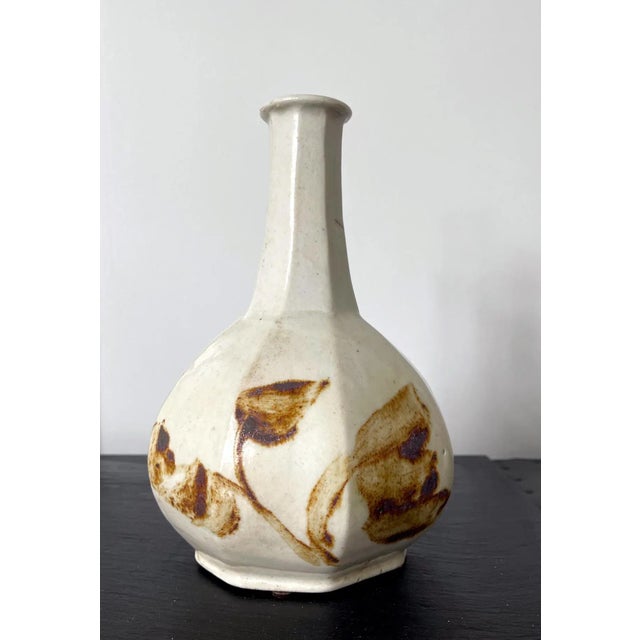 A Korean ceramic bottle with octagonal faceted form with underglaze copper red decoration. The robust bottle with the long...