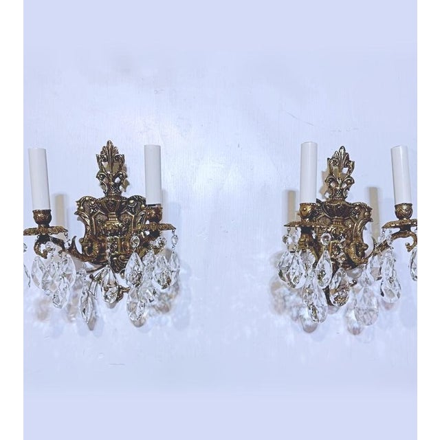 A striking pair of elaborate bronze sconces in the Belle Epoque style. The bronze frame is very decorative and dressed...