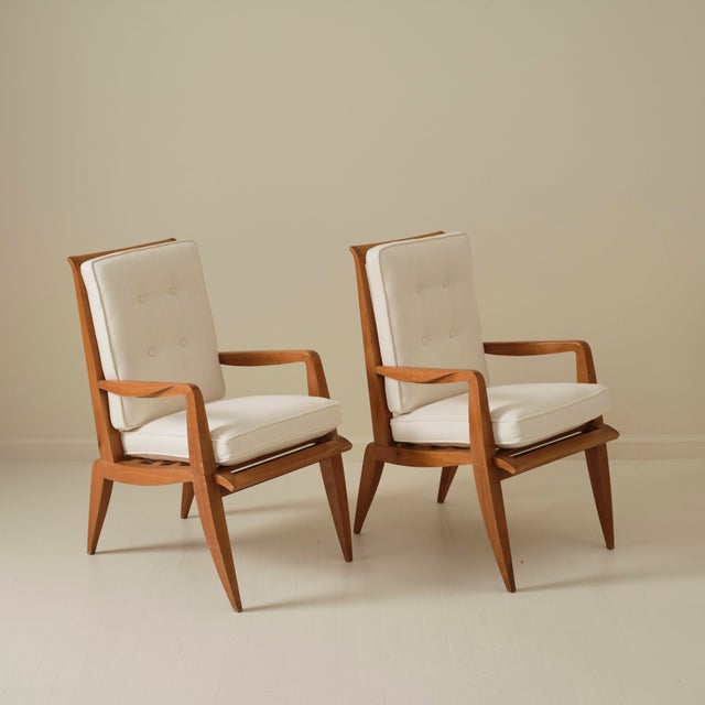 Pair of armchairs by Roger Landault, produced by Studium du Louvre, circa 1950. Crafted in rich colored cognac wood, each...