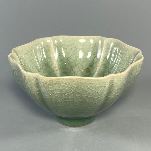 This vintage‑style flower‑petal shaped celadon bowl is covered with delicate natural crackle‑texture green glaze....