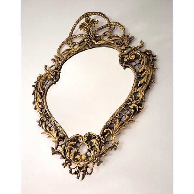 A magnificent Rococo-style Louis XV bronze mirror from mid-20th-century France. This mirror is crafted from solid bronze...