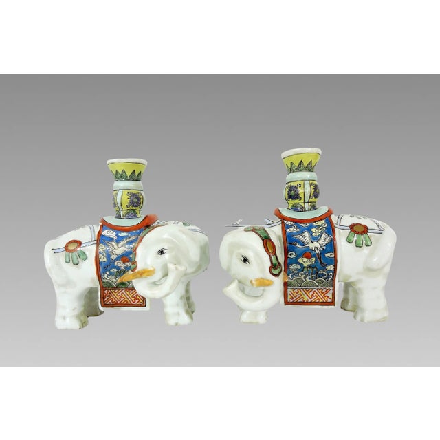 A pair of Export Chinese white porcelain elephant candle holders or joss stick holders with partial gilt accents. The...