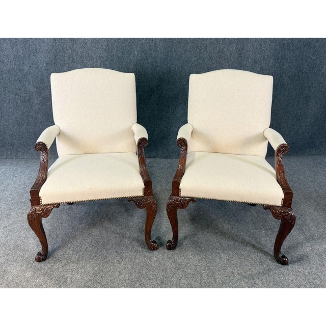 This pair of Baker Furniture Stately Homes Gainsborough arm chairs features elegant, hand-carved wood frames with graceful...