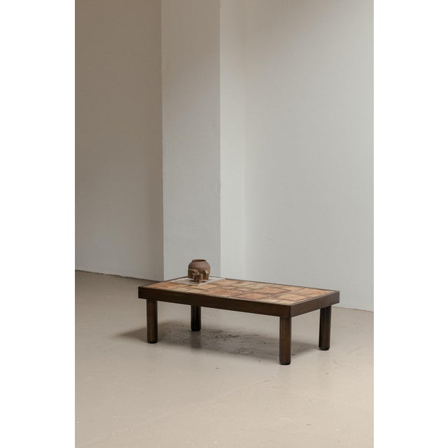 Coffee table produced by Vallauris in France around 1950. This table has a dark stained wooden base with ceramic tiles on...