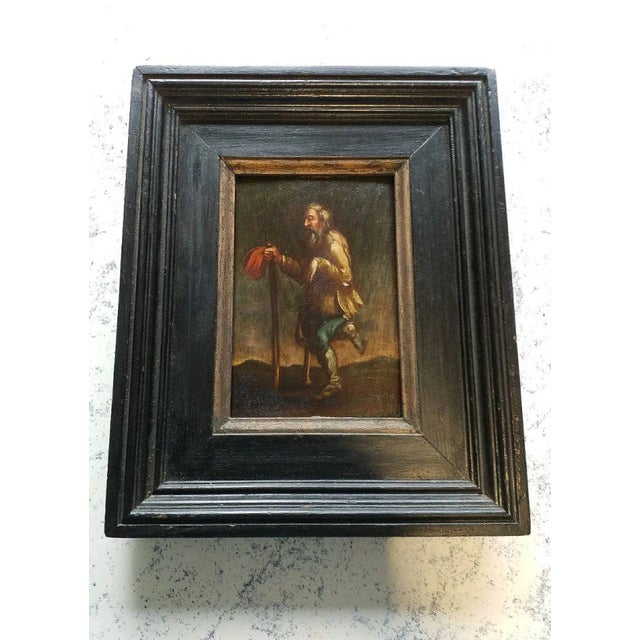 Striking small Baroque genre painting depicting a bearded elderly beggar in a dynamic, theatrical mid-stride pose. He...