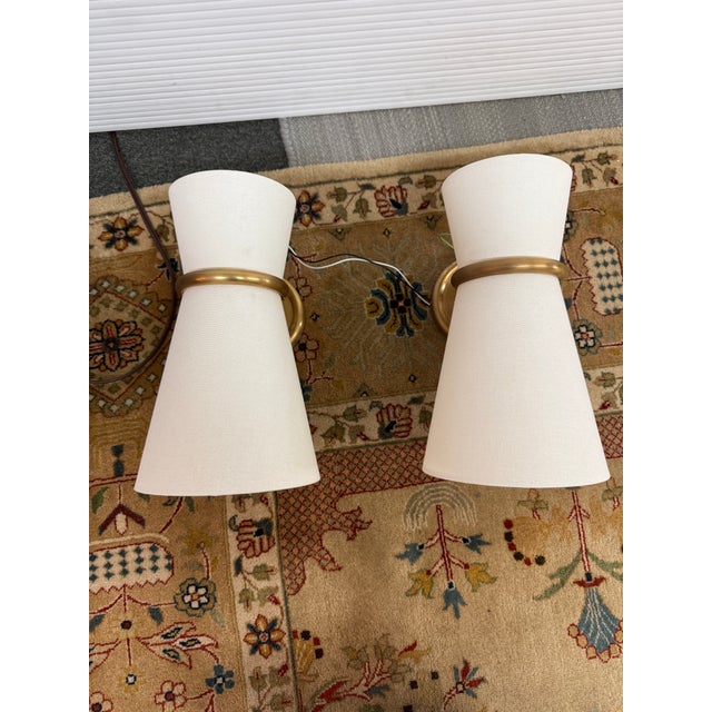 Design Plus Gallery presents the Clarkson Pivoting Wall Sconce by AERIN. A classic sconce that gives a soft glow, whether...