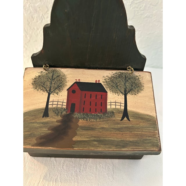 Charming wood salt box hand-painted in hunter green featuring a country Shaker home motif on lid. Hardware on back if...