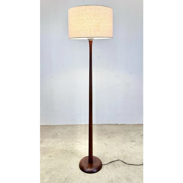 A fabulous solid teak floor lamp with a softly rounded weighted base and subtle curved sculptural body. Newly restored in...
