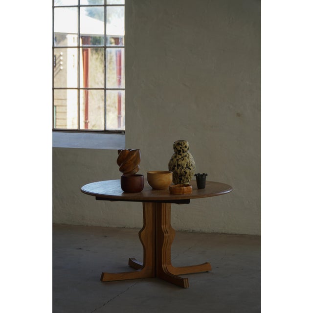 Elegant Danish Modern round dining table crafted in oak, featuring a beautifully grained tabletop and a sculptural...