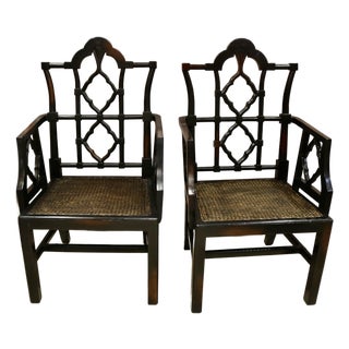 Vintage Chinoiserie Black Carved Wood Arm Chairs With Caned Seat - A Pair For Sale