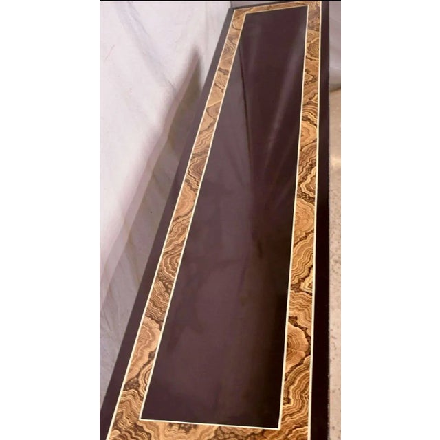 This is a sleek modern Ming style console table by Baker Furniture Company. The piece has an espresso finish with a high...