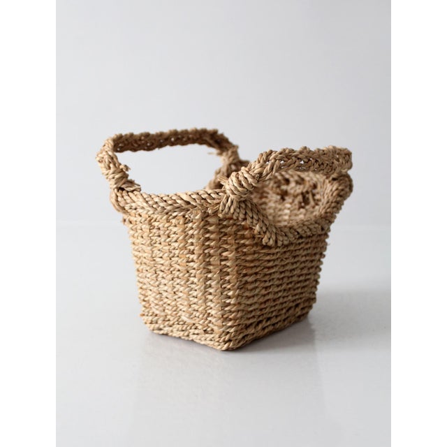 Vintage woven basket showcasing the beauty of natural materials and traditional handcrafted design. The rectangular form...