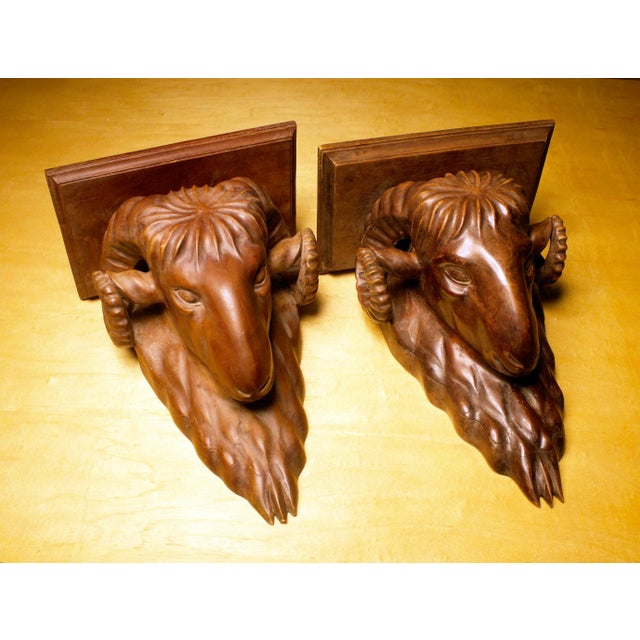 Incredible pair of late 19th century Swiss Black Forest carved ram's head wall/clock shelves. Heavy solid walnut, with the...