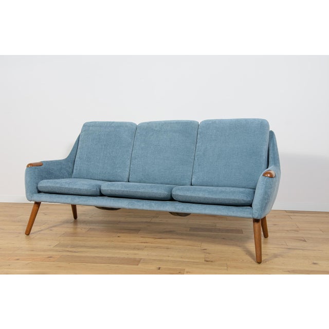 Three-seater sofa manufactured in Denmark in the 1960s. The sofa has oak armrests. The sofa has undergone a thorough...