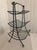 Lovely vintage tiered magazine rack or possible firewood caddy. Made of solid black wrought iron with brass-finished...