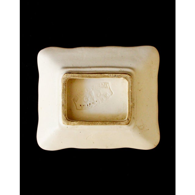 Small white glazed ceramic ashtray by Eugène Grandjean-Jourdan, decorated with a stylized animal in the basin and...