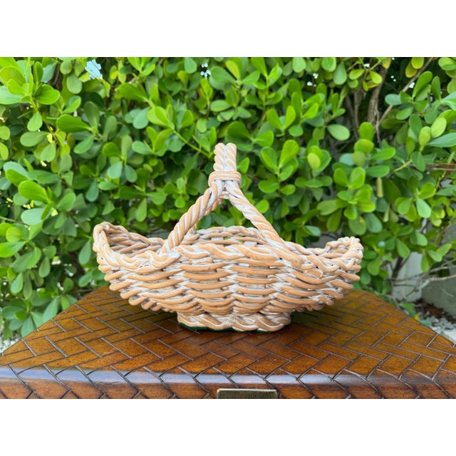Beautiful handcrafted Italian ceramic basket featuring a woven body, braided rim, and sculptural twisted handle. Finished...
