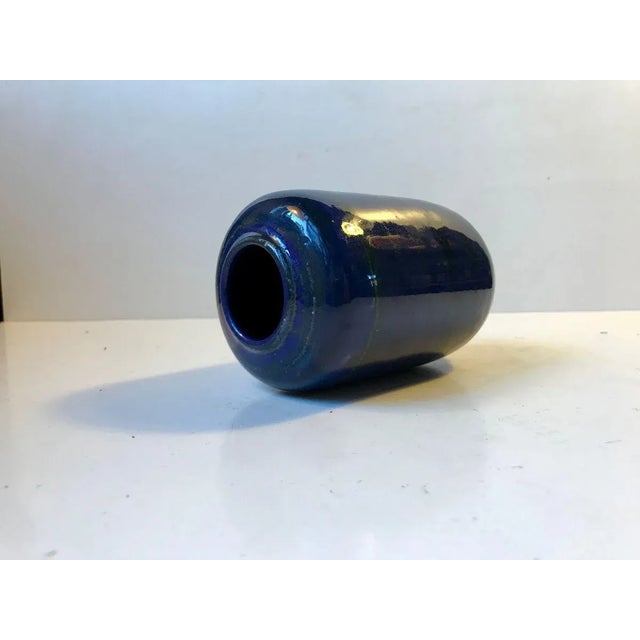 Organically shaped ceramic vase in blue glaze with green stripes. Designed by the German ceramist Gerhard Meisel and made...