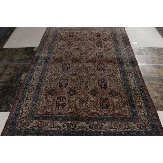 Hand-knotted in wool, a 7x11 antique Persian rug from Tehran showcasing fine craftsmanship of the 1920s with royal blue,...