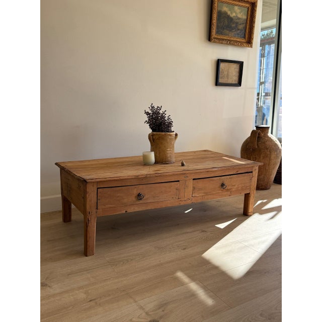 An inviting antique French coffee table crafted from richly grained fruitwood, its long, low proportions lending an...