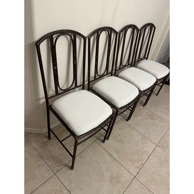 Great set of classic Hollywood Regency style dark metal or wrought iron dining side chairs with a distinctive loop-back...