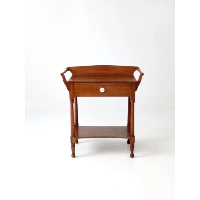 This is an antique washstand table from the late 19th century. The Victorian stand features a single drawers, towel bars...