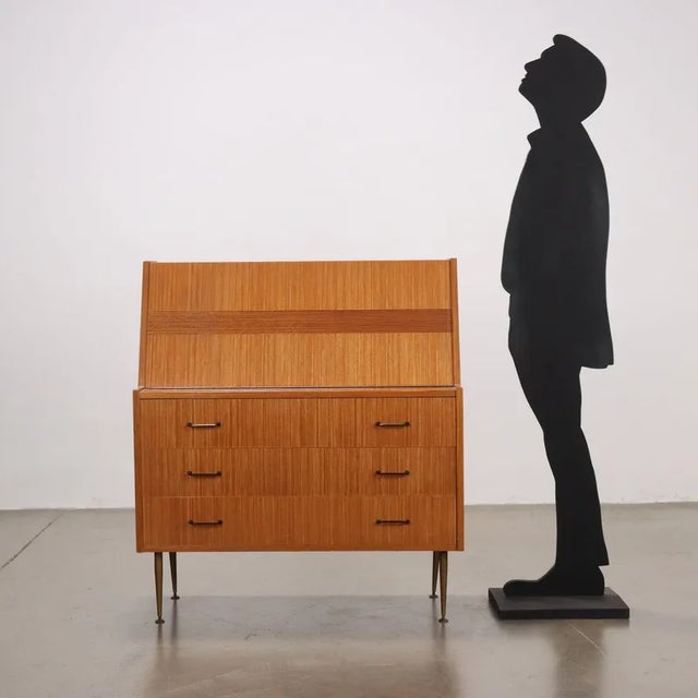 Drop-leaf desk with drawers, maple veneer with polyester finish, brass legs. This piece is attributed to the mentioned...