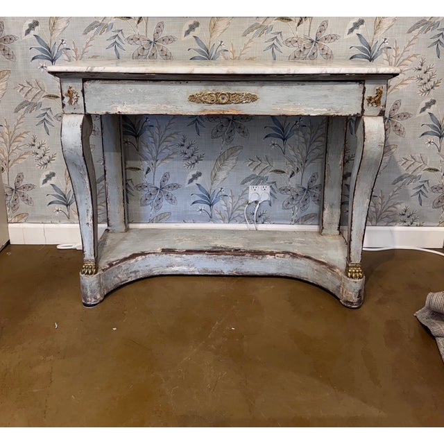 This elegant Early 19th century Swedish-style console table features a classic, curved silhouette with a distressed...