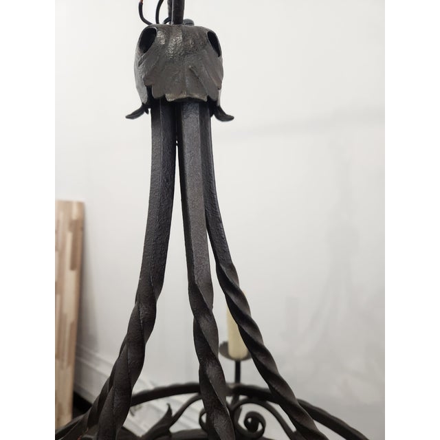 Round, black chandelier made of iron designed with classic Italian influences that emphasize elegance, balance, and rustic...