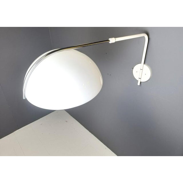 Vintage extendable wall lamp designed by Luigi Massoni for Guzzini. This rare wall light is made out of a plastic shade,...