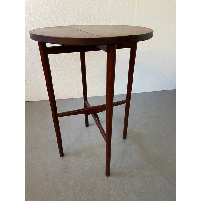 Walnut round drop-leaf side table from Singer and Sons, designed by Bertha Schaefer and made in Italy. This table was...