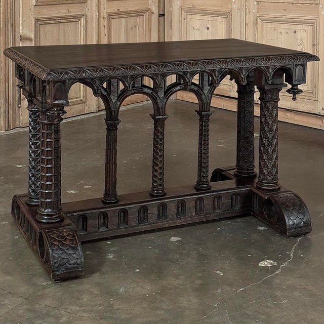 19th Century French Napoleon III Period Gothic Revival Walnut Library Table is an amazing example of the revival of the...