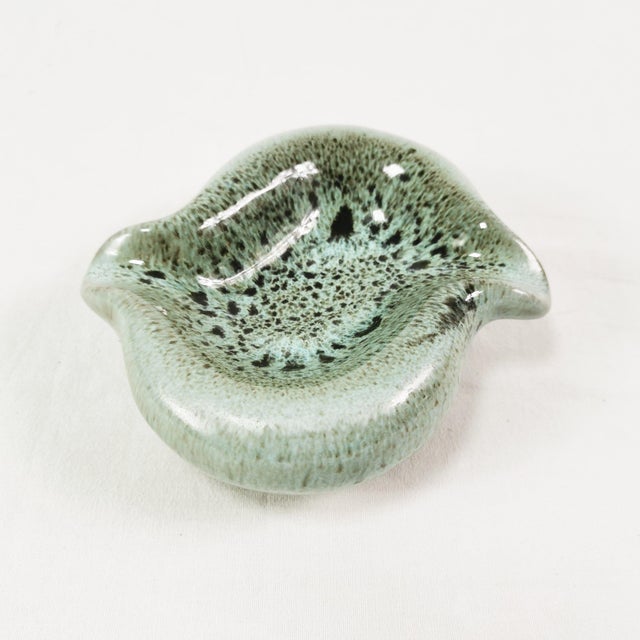 This ashtray originated in Denmark in the 1960s. It features an organic, modern form. Made of ceramic, it features...