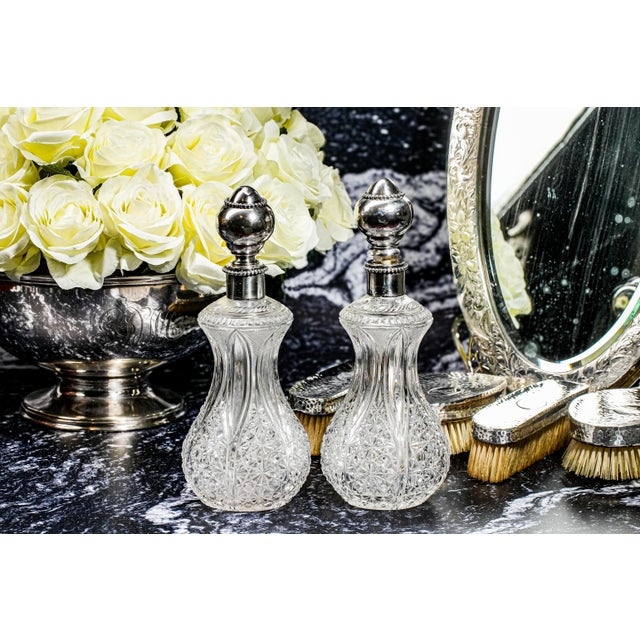 An exceptional statement of Victorian-era luxury, this magnificent pair of large antique crystal scent perfume bottles...